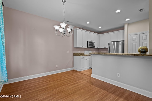 kitchen with pendant lighting, stainless steel appliances, light wood-style floors, white cabinets, and baseboards