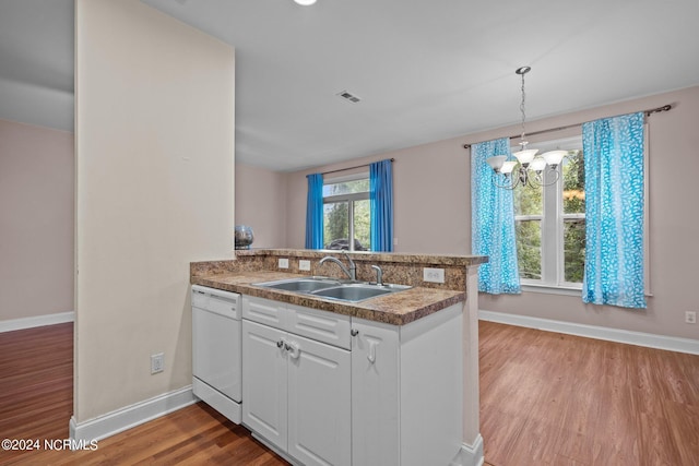 kitchen with pendant lighting, white cabinetry, a sink, dishwasher, and a peninsula