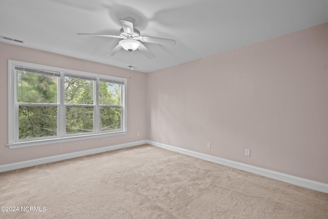 empty room featuring ceiling fan, carpet, visible vents, and baseboards