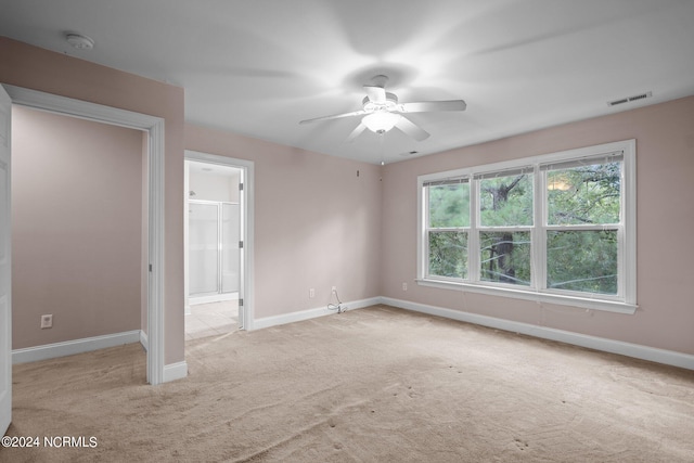 interior space with light carpet, ceiling fan, visible vents, and baseboards