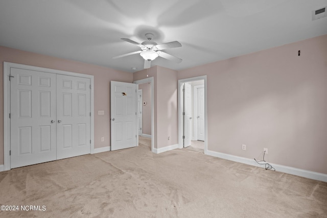 unfurnished bedroom with a closet, light carpet, visible vents, and baseboards