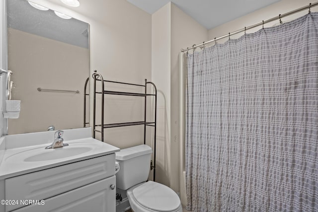 bathroom featuring toilet, a shower with shower curtain, and vanity