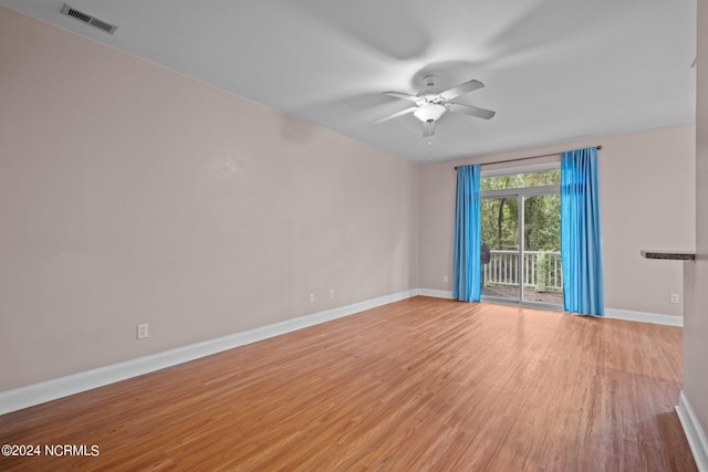 unfurnished room featuring ceiling fan, light wood finished floors, visible vents, and baseboards