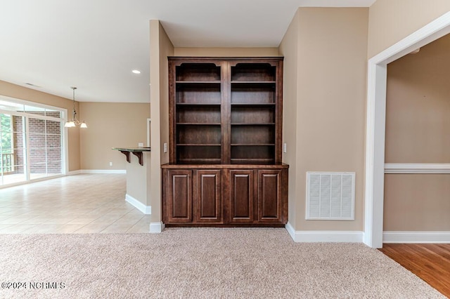 room details with carpet floors, visible vents, a notable chandelier, and baseboards