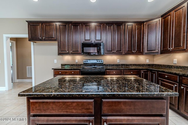 kitchen featuring light tile patterned floors, black appliances, and dark stone countertops