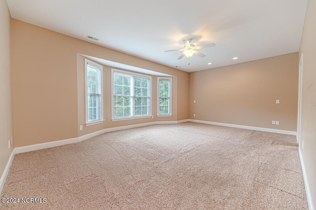 carpeted empty room with visible vents, baseboards, and recessed lighting