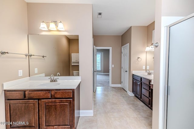 bathroom featuring two vanities, a sink, visible vents, and tile patterned floors