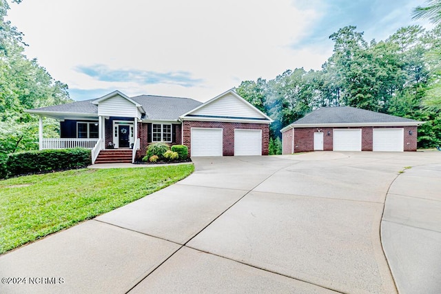 ranch-style home with covered porch, a garage, brick siding, driveway, and a front yard