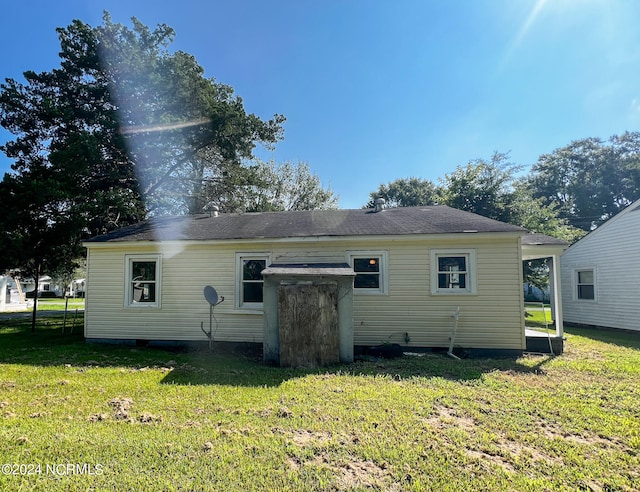 rear view of house featuring a yard