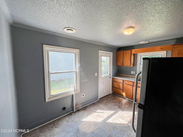 kitchen featuring a healthy amount of sunlight, black fridge, and a textured ceiling