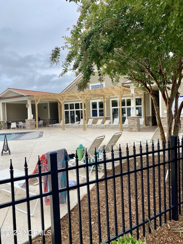 rear view of property featuring a community pool and a patio area