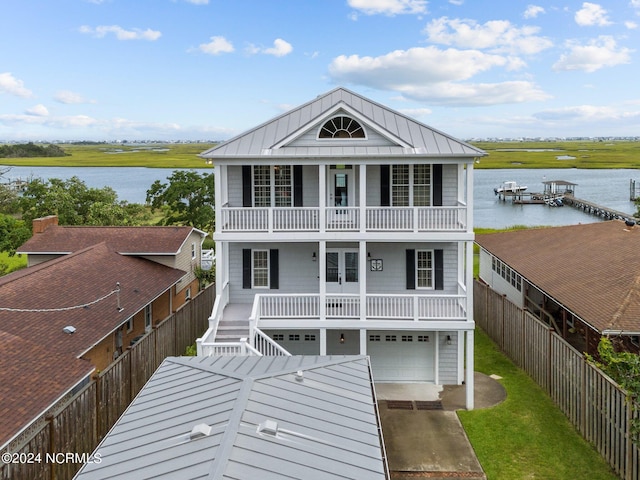 view of front of property featuring a porch, a water view, a balcony, and a garage