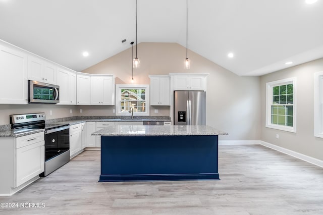 kitchen featuring white cabinetry, stainless steel appliances, plenty of natural light, pendant lighting, and a kitchen island