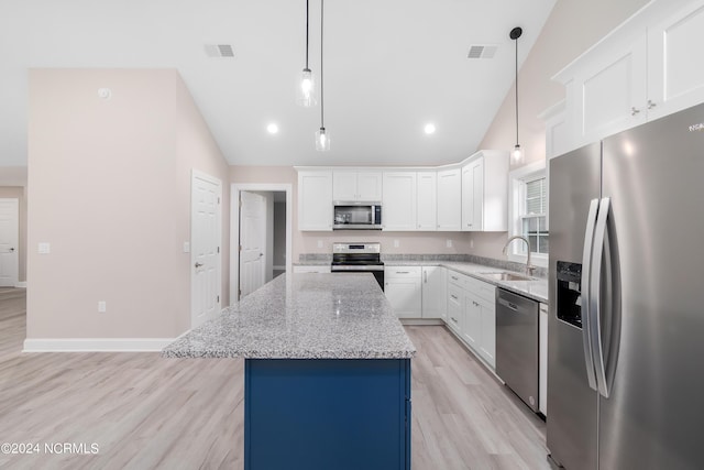 kitchen with pendant lighting, white cabinets, sink, a kitchen island, and stainless steel appliances