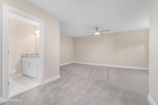 carpeted empty room with ceiling fan and sink