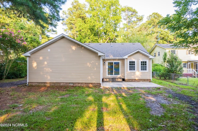 back of property with a yard and a patio area