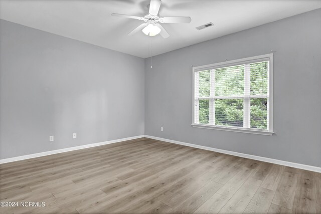 unfurnished room featuring ceiling fan, light wood-type flooring, and plenty of natural light