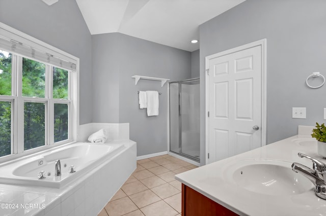 bathroom with double sink vanity, tile patterned floors, vaulted ceiling, and independent shower and bath