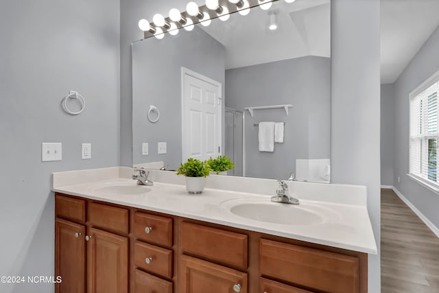 bathroom with hardwood / wood-style floors and dual vanity