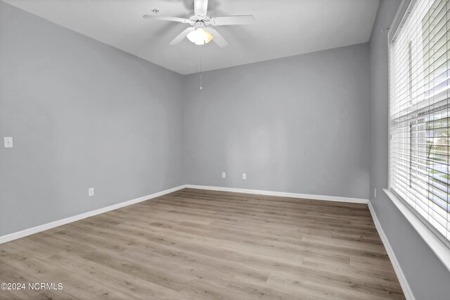 empty room with ceiling fan and light wood-type flooring