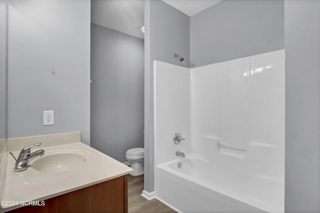 full bathroom with vanity, toilet, tub / shower combination, and hardwood / wood-style floors