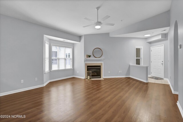 unfurnished living room with ceiling fan, vaulted ceiling, and hardwood / wood-style floors