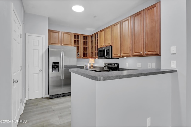 kitchen featuring stainless steel appliances, kitchen peninsula, and light hardwood / wood-style floors