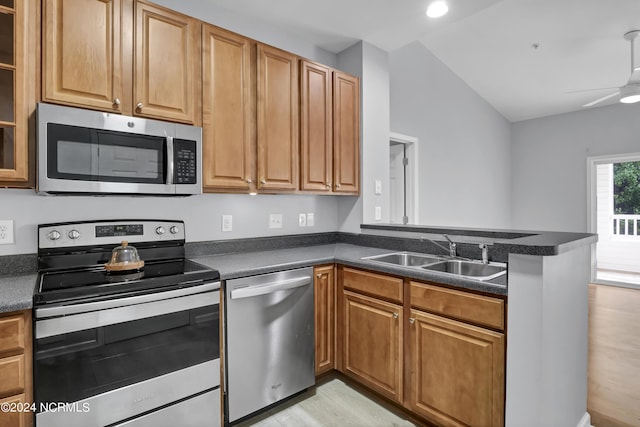 kitchen with sink, ceiling fan, stainless steel appliances, vaulted ceiling, and kitchen peninsula