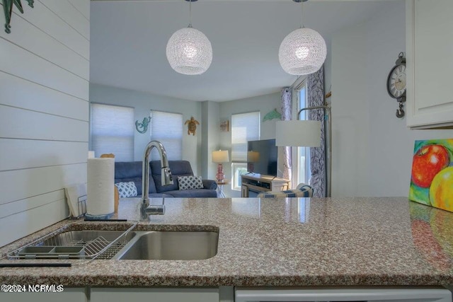 kitchen with dark stone counters, sink, and white cabinets