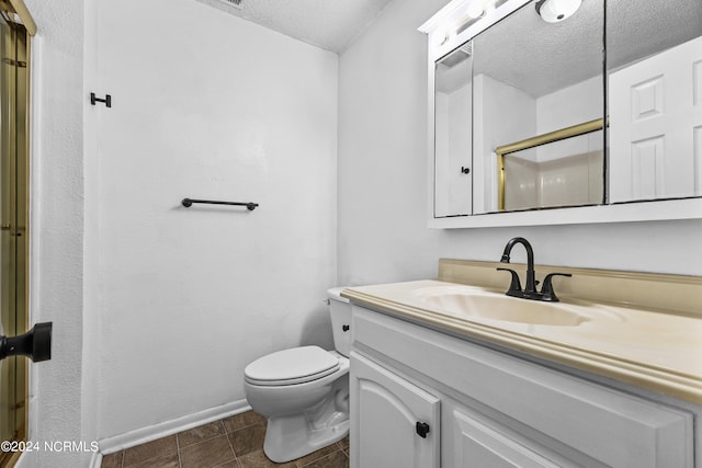 bathroom featuring tile patterned floors, a textured ceiling, vanity, and toilet