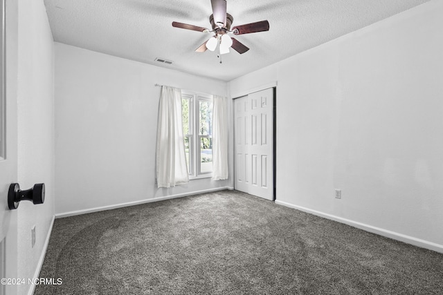 spare room featuring ceiling fan, a textured ceiling, and carpet flooring