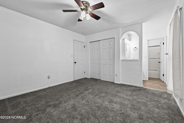 unfurnished bedroom featuring ceiling fan, a textured ceiling, and carpet