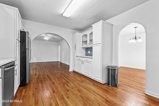 kitchen featuring appliances with stainless steel finishes, light hardwood / wood-style flooring, tasteful backsplash, and white cabinetry