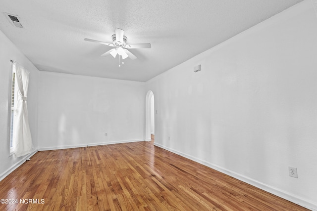 spare room with ceiling fan, wood-type flooring, and a textured ceiling