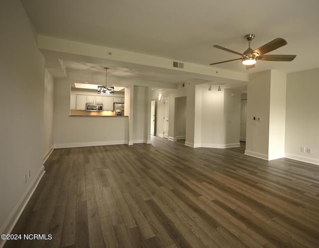 unfurnished living room with ceiling fan and dark wood-type flooring