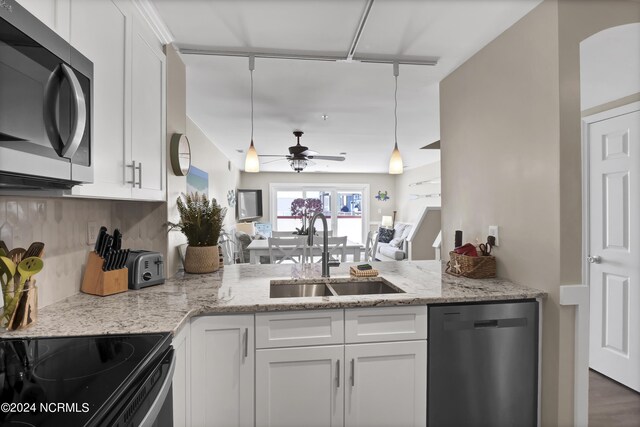 kitchen featuring white cabinets, light stone counters, ceiling fan, stainless steel appliances, and wood-type flooring