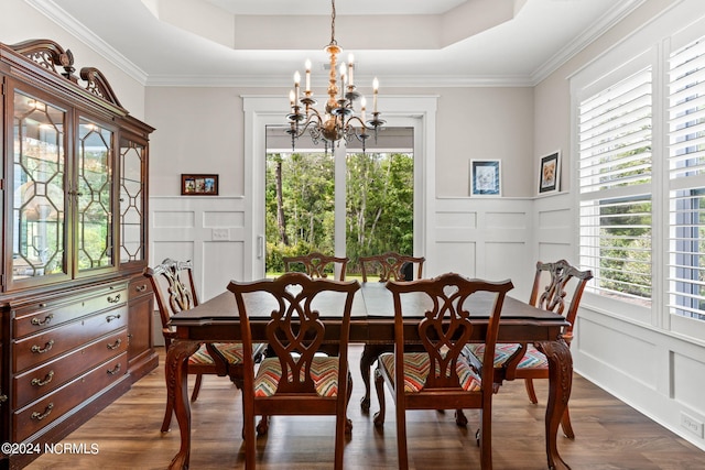 dining space with a raised ceiling, crown molding, a chandelier, and dark hardwood / wood-style flooring