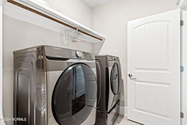 laundry area with light tile patterned flooring and washing machine and clothes dryer