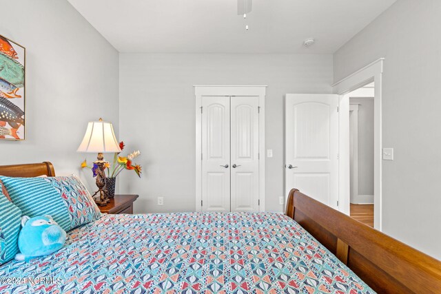 bedroom with ceiling fan, a closet, and wood-type flooring