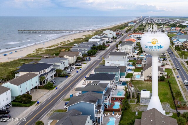 birds eye view of property with a water view and a beach view