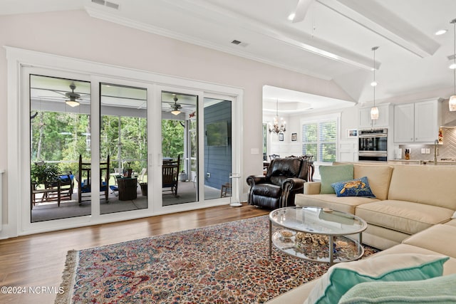 living room featuring lofted ceiling with beams, ceiling fan with notable chandelier, and dark hardwood / wood-style flooring