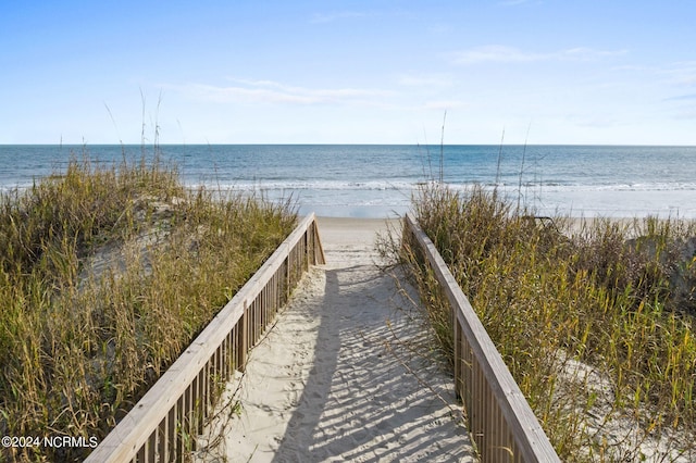 view of home's community featuring a water view and a beach view