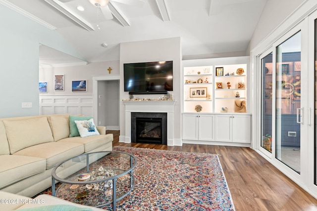 living room featuring lofted ceiling with beams, crown molding, hardwood / wood-style floors, and ceiling fan