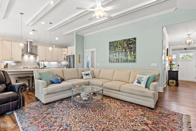 living room featuring sink, vaulted ceiling with beams, ceiling fan, crown molding, and dark wood-type flooring