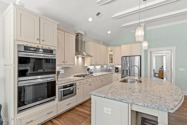 kitchen featuring light hardwood / wood-style floors, appliances with stainless steel finishes, backsplash, and wall chimney range hood