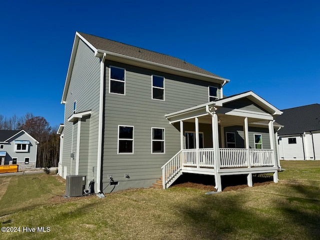 rear view of property featuring covered porch, a yard, and central air condition unit