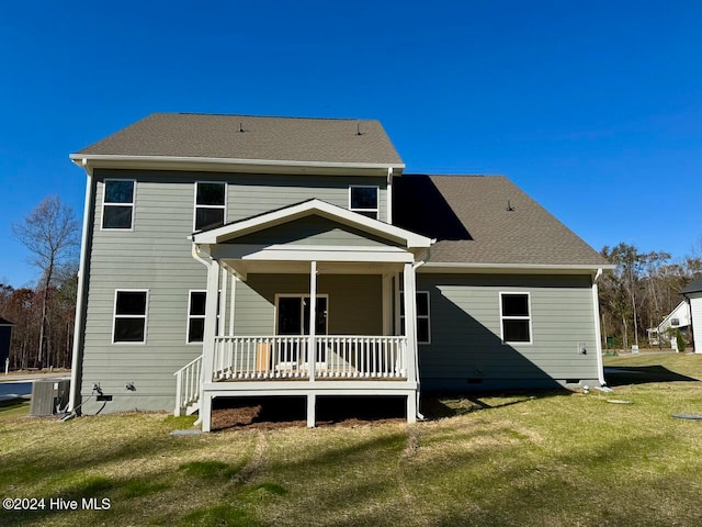 rear view of house with a porch, a yard, and central air condition unit