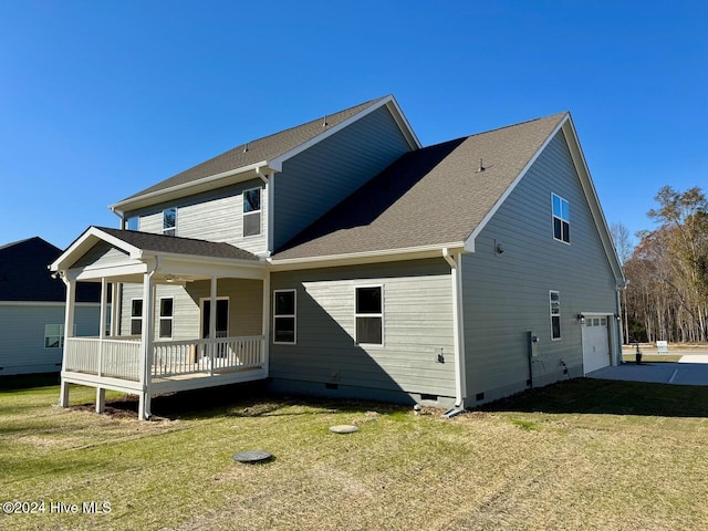 back of house with a yard, covered porch, and a garage