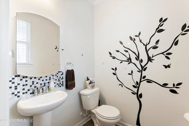 bathroom featuring decorative backsplash, sink, and toilet