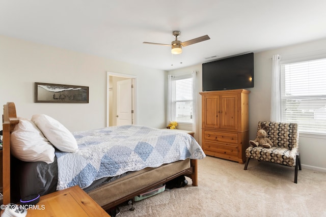 bedroom with ceiling fan, multiple windows, and light carpet